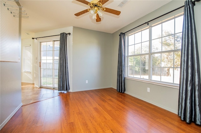 unfurnished room with light hardwood / wood-style floors, ceiling fan, and a healthy amount of sunlight