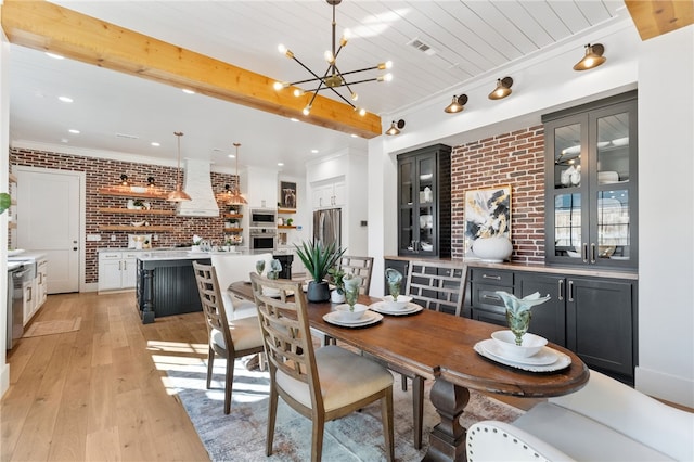 dining room with brick wall, a chandelier, wood ceiling, light hardwood / wood-style floors, and beam ceiling