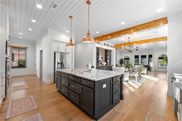 kitchen featuring white cabinets, hanging light fixtures, a center island, stainless steel fridge with ice dispenser, and beam ceiling