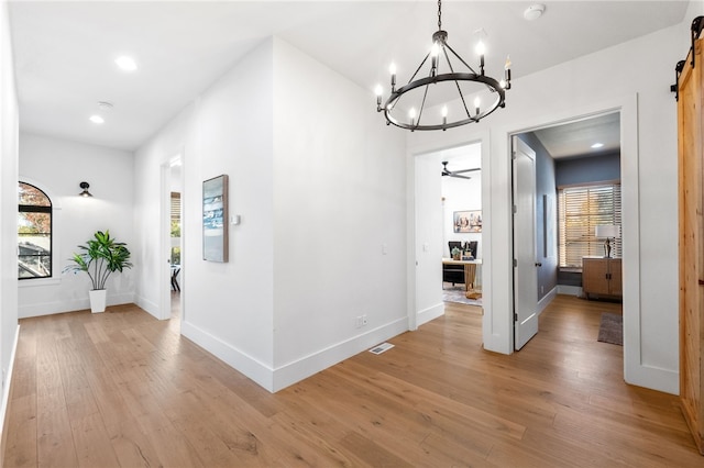 hallway featuring a barn door and light hardwood / wood-style flooring