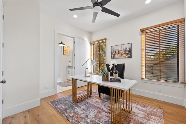 office with light hardwood / wood-style floors and ceiling fan