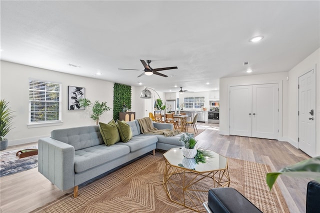 living room with ceiling fan and light hardwood / wood-style flooring