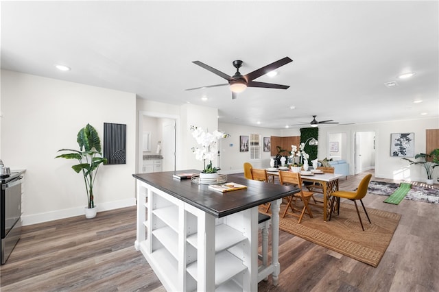 kitchen with ceiling fan, dark wood-type flooring, wood counters, and electric stove