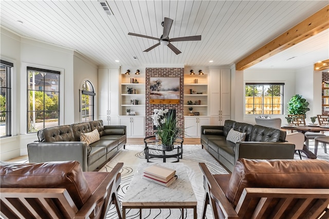 living room with wood ceiling, ceiling fan, beam ceiling, ornamental molding, and built in shelves