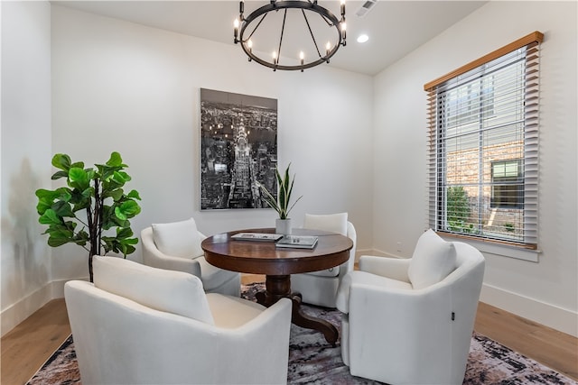 sitting room with wood-type flooring and an inviting chandelier