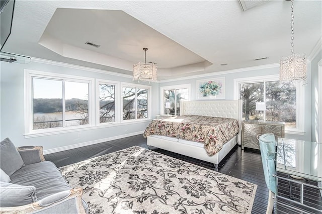 bedroom featuring ornamental molding, a chandelier, a tray ceiling, and dark hardwood / wood-style flooring