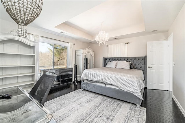 bedroom featuring a notable chandelier, dark hardwood / wood-style flooring, and a raised ceiling