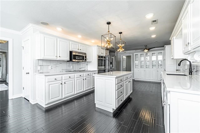 kitchen featuring sink, a kitchen island, white cabinets, and stainless steel appliances