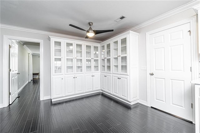 interior space featuring dark hardwood / wood-style flooring, ornamental molding, and ceiling fan