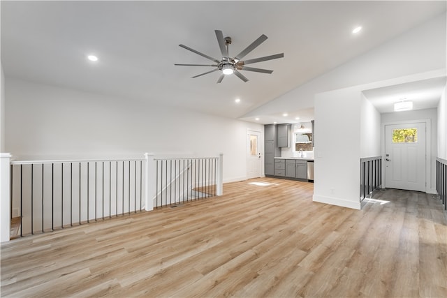 unfurnished living room featuring lofted ceiling, sink, ceiling fan, and light hardwood / wood-style flooring