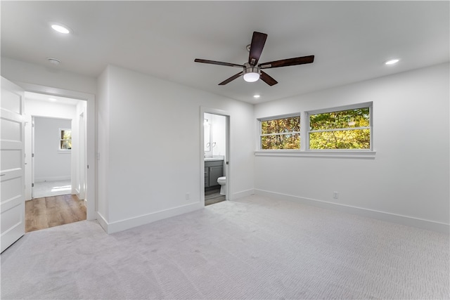 unfurnished bedroom with light carpet, ceiling fan, and ensuite bathroom