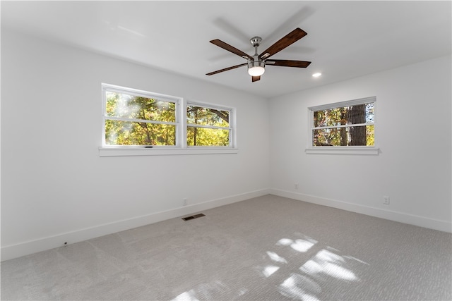 carpeted empty room with ceiling fan and a healthy amount of sunlight