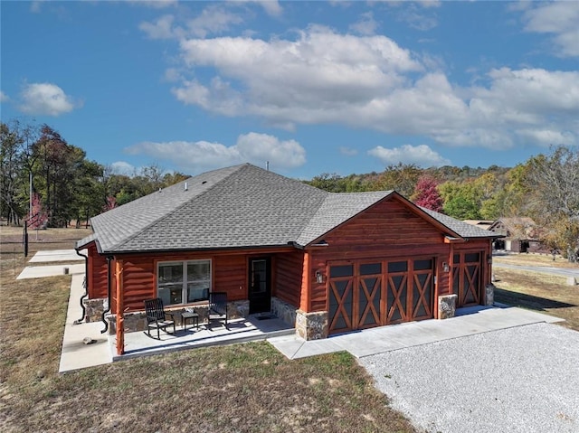 114 Ledgewood, Berryville, AR 72616 - back of property featuring an attached garage, roof with shingles, stone siding, and driveway