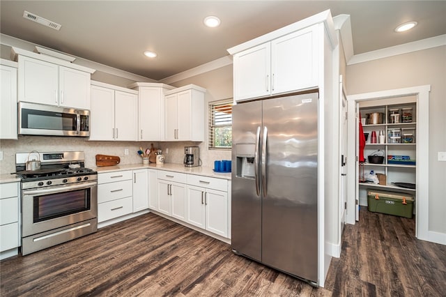 kitchen featuring crown molding, appliances with stainless steel finishes, dark hardwood / wood-style floors, and white cabinets