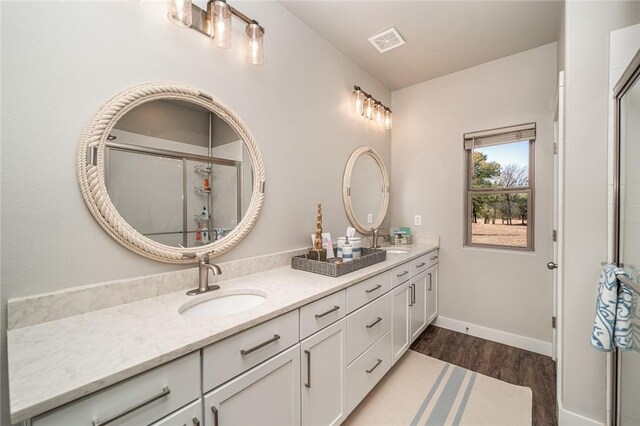 114 Ledgewood, Berryville, AR 72616 - bathroom featuring double vanity, wood finished floors, tiled shower, and baseboards