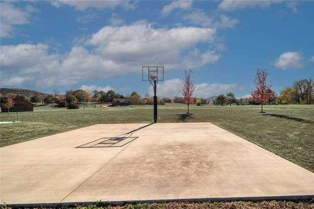 view of basketball court with a yard