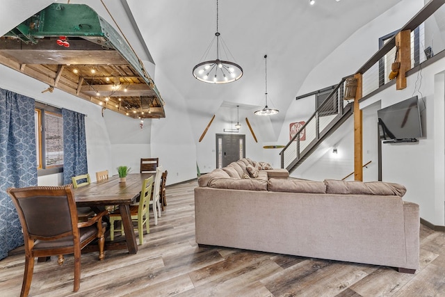 living room featuring beamed ceiling, a chandelier, and wood-type flooring