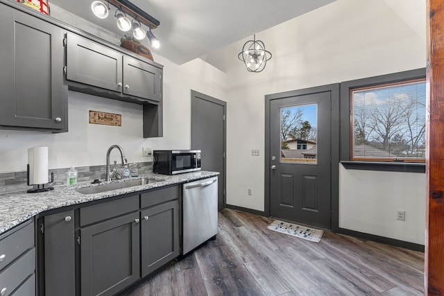 kitchen featuring dark hardwood / wood-style floors, gray cabinetry, sink, an inviting chandelier, and appliances with stainless steel finishes