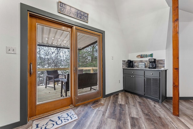 doorway featuring lofted ceiling and wood-type flooring