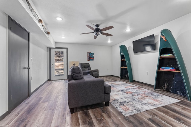 living area featuring hardwood / wood-style floors and ceiling fan