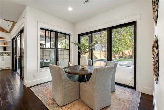 dining room featuring lofted ceiling, dark hardwood / wood-style floors, and plenty of natural light