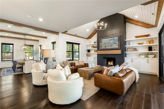 living room featuring lofted ceiling with beams, dark wood-type flooring, a fireplace, and a wealth of natural light