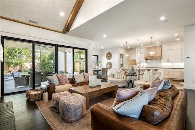 living room with sink, dark wood-type flooring, and vaulted ceiling