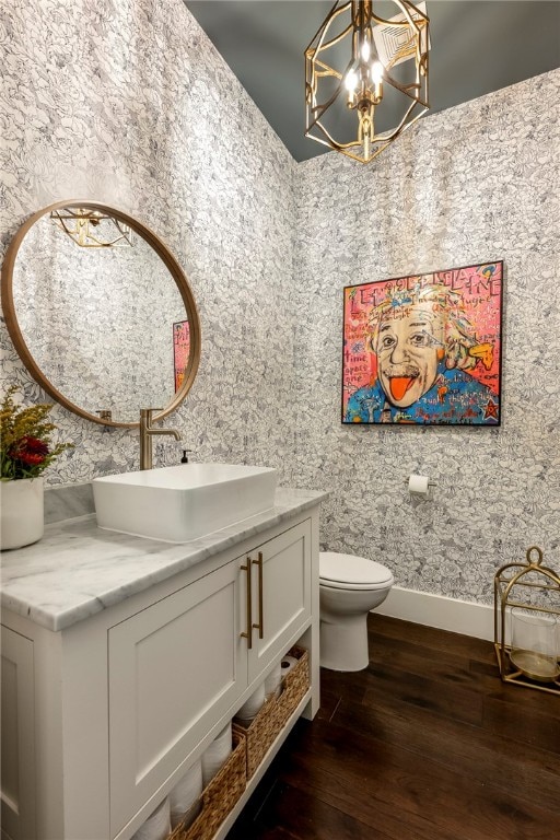 bathroom featuring vanity, a notable chandelier, hardwood / wood-style floors, and toilet