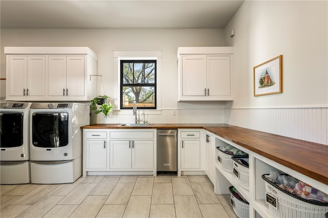 washroom featuring sink, washing machine and clothes dryer, and cabinets