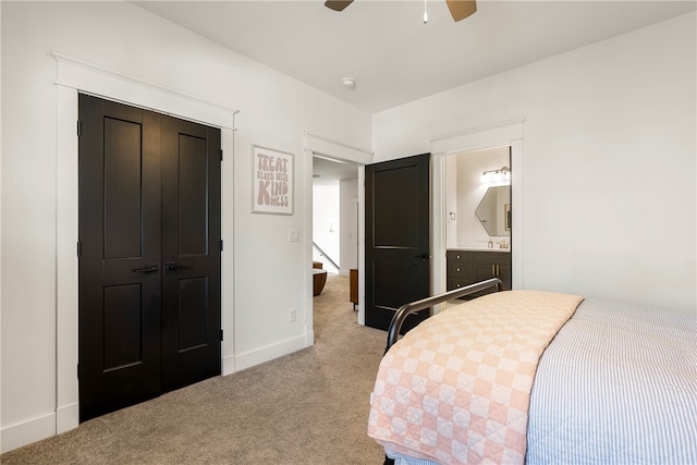 carpeted bedroom with ensuite bath, a closet, and ceiling fan