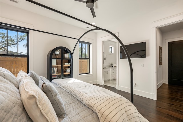 bedroom featuring connected bathroom, ceiling fan, multiple windows, and dark hardwood / wood-style flooring