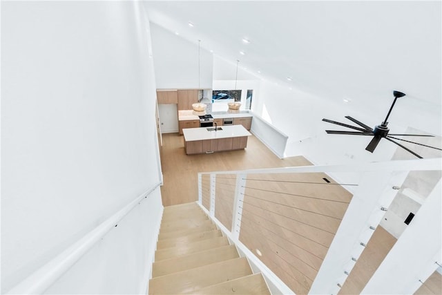 stairway featuring sink, high vaulted ceiling, ceiling fan, and wood-type flooring