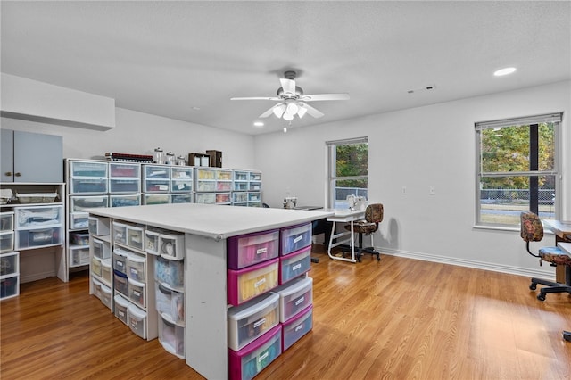 interior space with a textured ceiling, light wood-type flooring, a healthy amount of sunlight, and ceiling fan