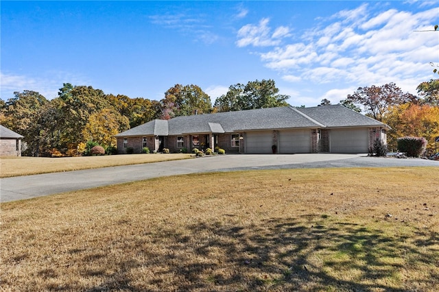 single story home featuring a front lawn and a garage