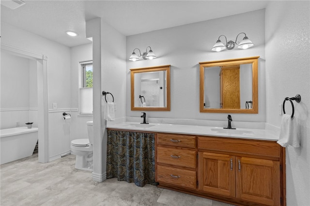 bathroom with vanity, a tub, and toilet