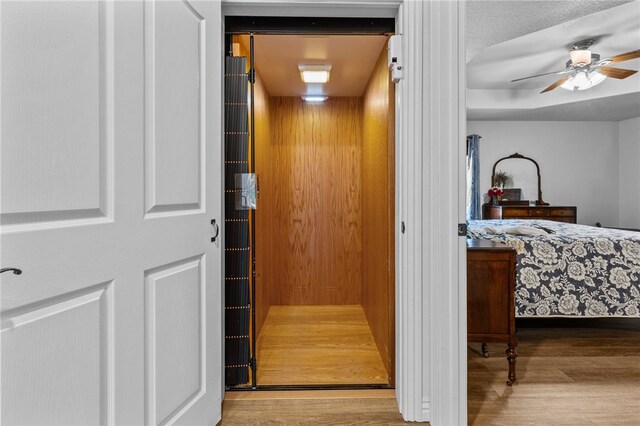 interior details with hardwood / wood-style flooring, elevator, and ceiling fan