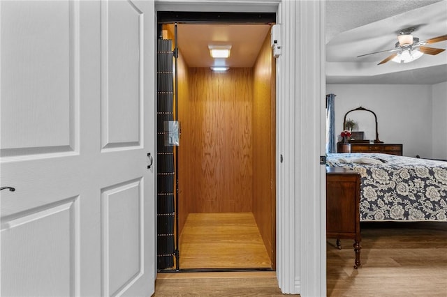 9299 W Forest Hills Dr, Fayetteville, AR 72704 - bedroom view of elevator, wood finished floors, and a ceiling fan