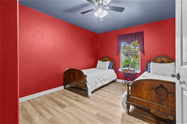 bedroom with light hardwood / wood-style flooring and ceiling fan