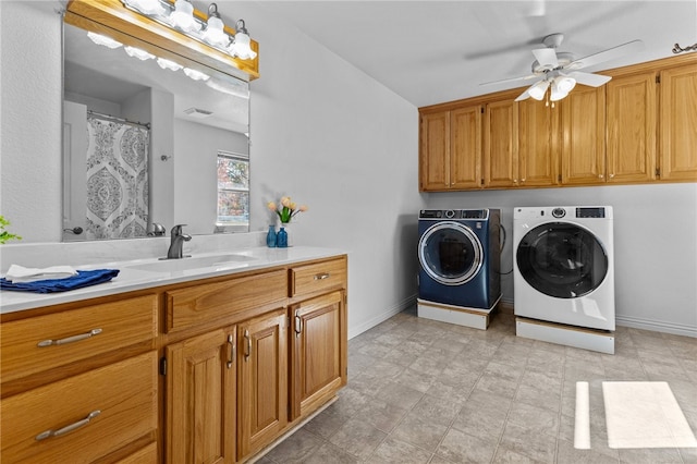 washroom with ceiling fan, cabinets, sink, and washing machine and clothes dryer