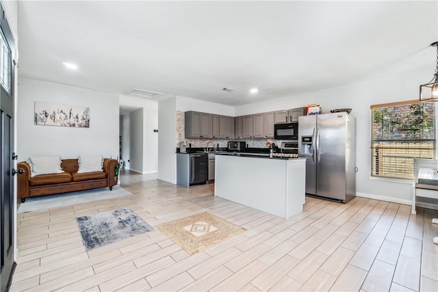 kitchen with decorative backsplash, a kitchen island, black appliances, light wood-type flooring, and gray cabinets