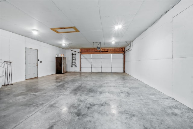 garage featuring stainless steel fridge and a garage door opener