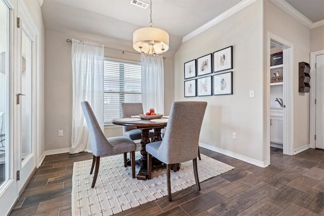 dining room with crown molding, dark wood-type flooring, and a chandelier