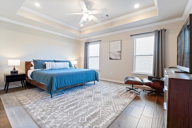 bedroom featuring crown molding, ceiling fan, a tray ceiling, and hardwood / wood-style floors