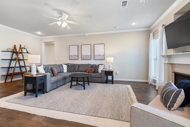 living room featuring crown molding, a fireplace, dark hardwood / wood-style floors, and ceiling fan