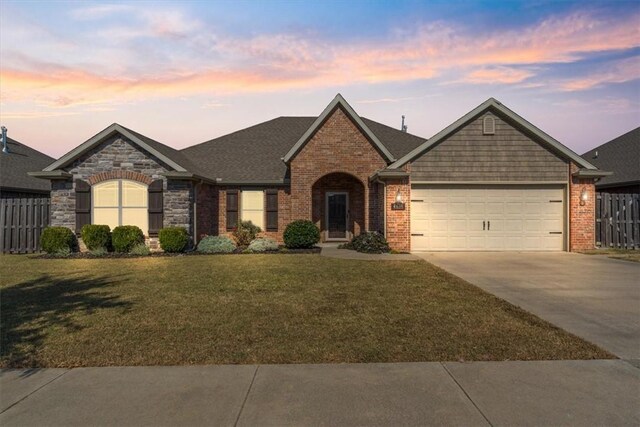 ranch-style house with a garage and a lawn