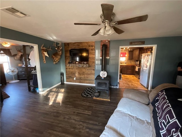 52720 S 680, Colcord, OK 74338 - living room with a wood stove, a ceiling fan, wood finished floors, and baseboards