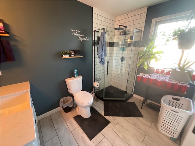 bathroom with a shower with door, toilet, and vanity