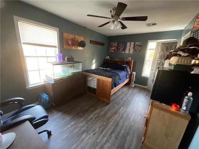 bedroom featuring dark wood-type flooring, ceiling fan, and multiple windows