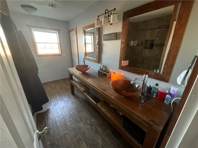 bathroom with vanity, wood-type flooring, and tiled shower