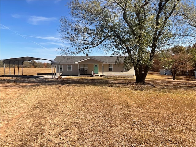 back of house featuring covered porch, a lawn, and a carport